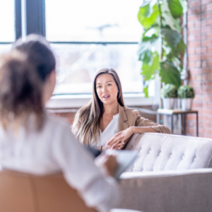 Two women sitting in a modern office space, engaged in a deep and focused mentorship conversation
