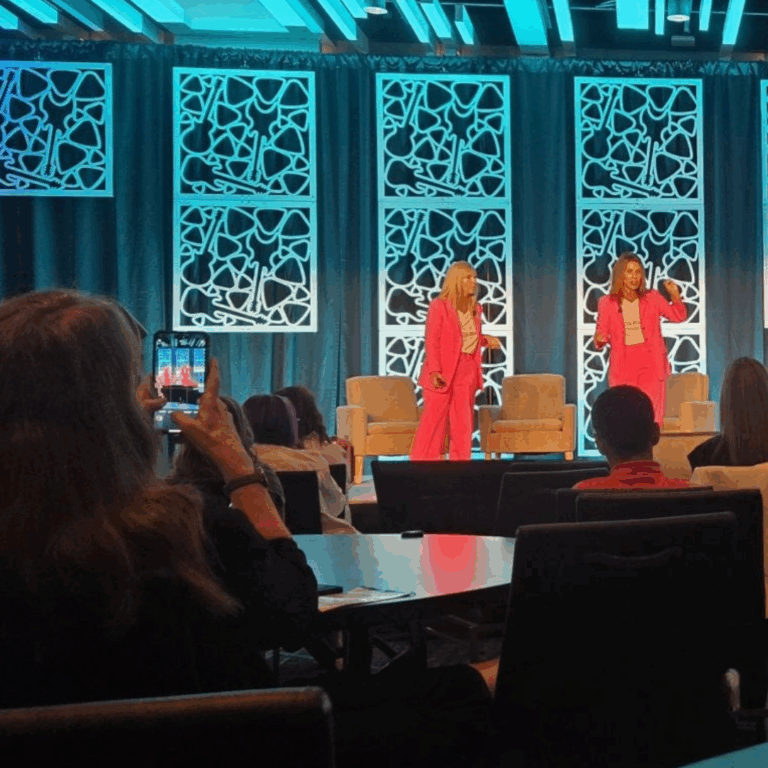 Audience member capturing photo of WIA keynote speakers on stage